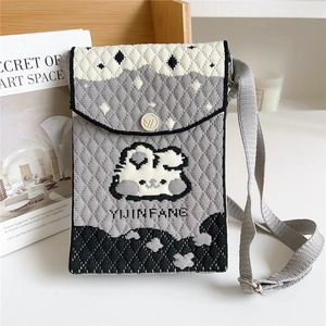 Detail of grey knitted crossbody phone bag with cartoon bunny and brand embroidery