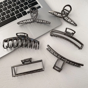 Minimalist gunmetal hair claws set of 6 in various geometric shapes on a white desk