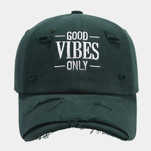 Detailed view of Good Vibes Only embroidery on dark green vintage distressed baseball cap