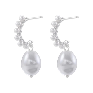 Macro detail of silver drop earrings featuring white rice pearls and teardrop pendants
