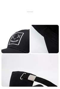 Detail of adjustable metal buckle and embroidered smiley patch on black cotton baseball cap