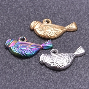 Detailed view of small bird charms in gold, silver, and rainbow stainless steel finishes