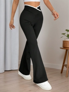 Women's high waist flared knit trousers in black with white V-shaped contrast waistband