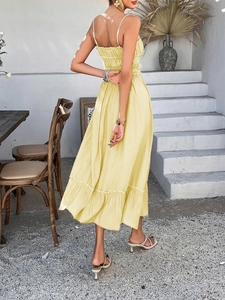 Detail of yellow backless summer dress featuring shirred elastic back and ruffle hem