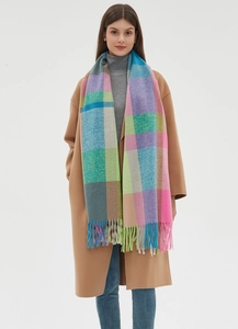 Close-up of thick plaid scarf texture with vibrant pink blue and yellow wool fringe