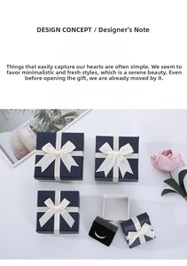 Navy blue jewelry gift box with cream ribbon bow and black sponge ring insert