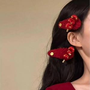 Detail of red velvet Chinese style hair clips worn on black hair for festive look