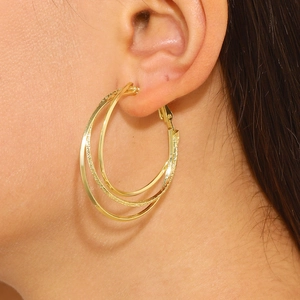 Boucles d'oreilles créoles dorées à trois couches, aspect mat et poli sur mannequin