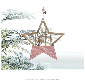 Pink wooden star ornament with reindeer carving hanging on a snowy branch