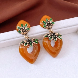Detailed close-up of vintage amber heart earrings with golden rose and green enamel leaves