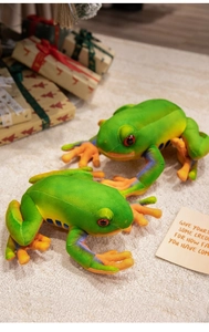 Detail view of plush frog toys with orange webbed feet and soft green fabric texture