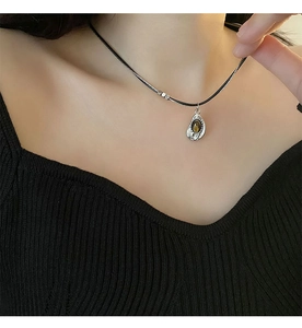 Close-up of double-layer necklace with amber tiger eye stone pendant on black leather cord
