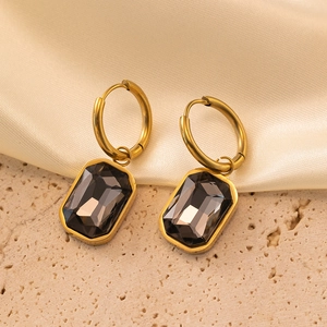 Détail de créoles plaquées or 18 carats avec pendentifs en zircon gris fumé taille émeraude