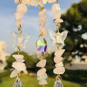 Detail of pink crystal chips wind chime with iridescent teardrop prisms and butterfly charms
