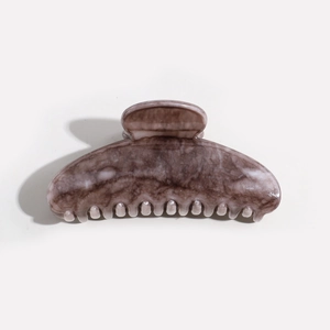 Detailed close-up of brown marble texture hair claw clip with glossy resin finish
