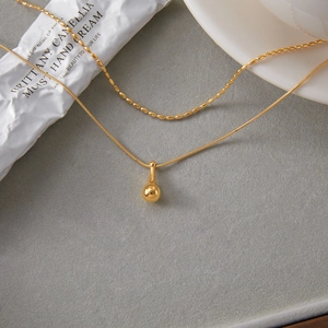 Gold double-layered stainless steel necklace featuring bead chain and waterdrop pendant