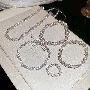 Elegant 5-piece pink pearl and diamond-studded jewelry set including necklace and bracelets