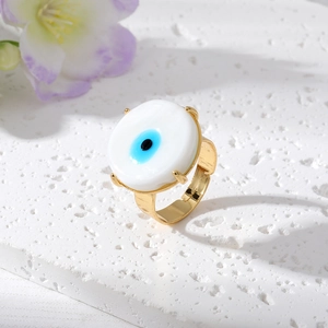 Dettaglio dell'anello malocchio placcato oro con smalto blu su superficie in pietra