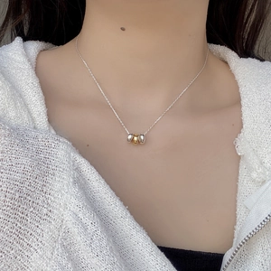 Close-up of minimalist tricolor interlaced rings pendant on a silver necklace chain