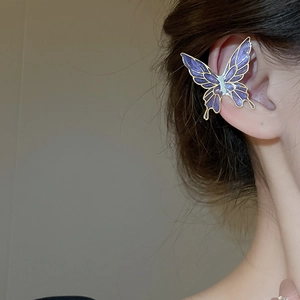 Detail view of purple gradient butterfly ear cuff with gold metallic edges on model