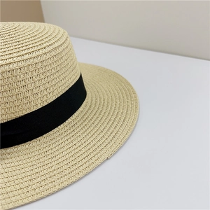Close-up of woven straw texture and black ribbon detail on vintage boater hat