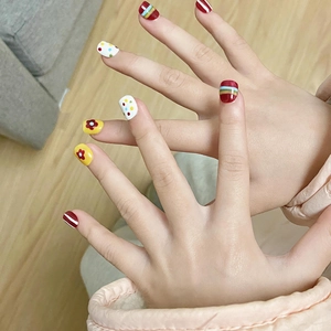 Kids press-on nails featuring rainbow patterns and small flower designs in vivid colors