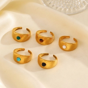 Set of five gold adjustable rings with colorful natural stone inlays on beige silk