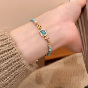 Close-up of vintage beaded bracelet with turquoise, pearls, and gold-tone details on wrist