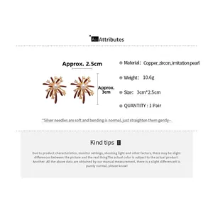 Detail view of fireworks earrings with brown enamel petals and center pearl accents