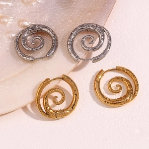 Detailansicht der spiralförmigen Creolen in Gold und Silber mit Wassertropfen