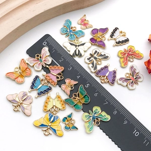 Flat lay of colorful enamel butterfly charms with a ruler for size reference