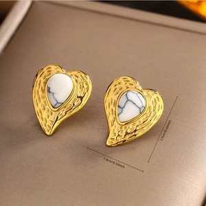 Macro detail of heart stud earring in 18K gold finish with size dimensions 1.7cm