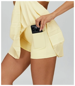 Detail of light yellow tennis skort showing built-in shorts with a side phone pocket
