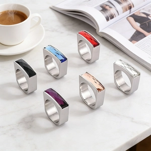 Detailed view of colorful rectangular glass gemstone rings on marble surface