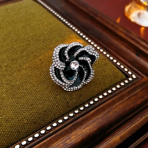 Detail of flower necklace on dark velvet with black enamel and sparkling rhinestones