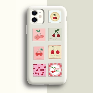 Gros plan d'une coque de téléphone blanche avec illustrations de cerises roses et rouges
