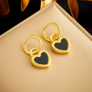 Detailed macro view of 18K gold-plated heart earrings displayed on a soft jewelry box