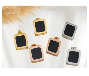 Detailed view of rectangular Roman numeral earrings in gold, silver and rose gold