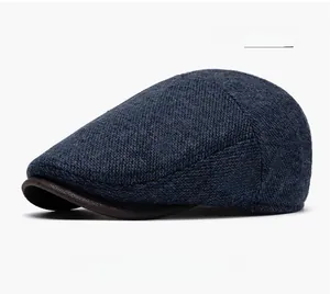 Detailed side view of navy blue newsboy cap with contrasting dark brown leather visor