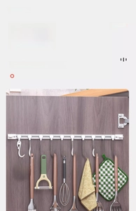 Detail showing white sliding cabinet hooks holding kitchen utensils on a smooth track