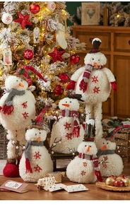 Dettaglio di pupazzi di neve in peluche con paillettes e sciarpe in un ambiente accogliente
