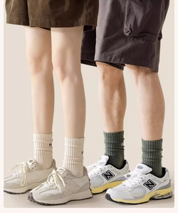 Détail de chaussettes mi-hautes en coton côtelé beige et vert foncé portées par un mannequin