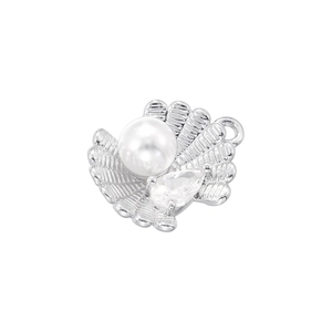 Detail of a silver shell pendant featuring a white pearl and a clear drop-shaped gemstone