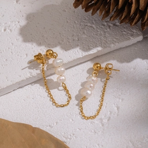 Elegant gold pearl tassel earrings with freshwater pearls on a textured white surface