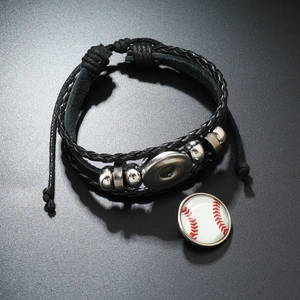 Détail d'un bracelet en cuir tressé noir avec perles en métal et bouton pression baseball