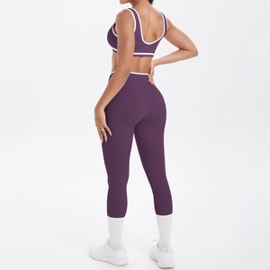 Detail der Cross-Waist-Yoga-Leggings und des Sport-BHs mit weißen Paspeln in dunklem Lila
