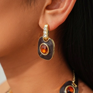 Close-up of vintage gold necklace with purple enamel and orange gemstone details
