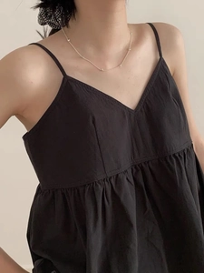 Detail of black V-neck camisole top with pleated bust and cotton linen fabric texture