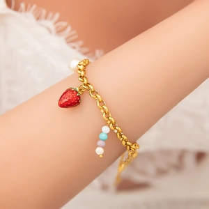 Handmade stainless steel bracelet with strawberry pendant and colorful beads on wrist