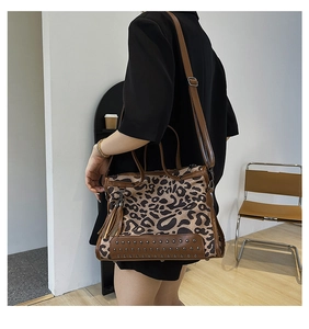 Detail view of leopard print handbag with leather tassels and metal studs decoration
